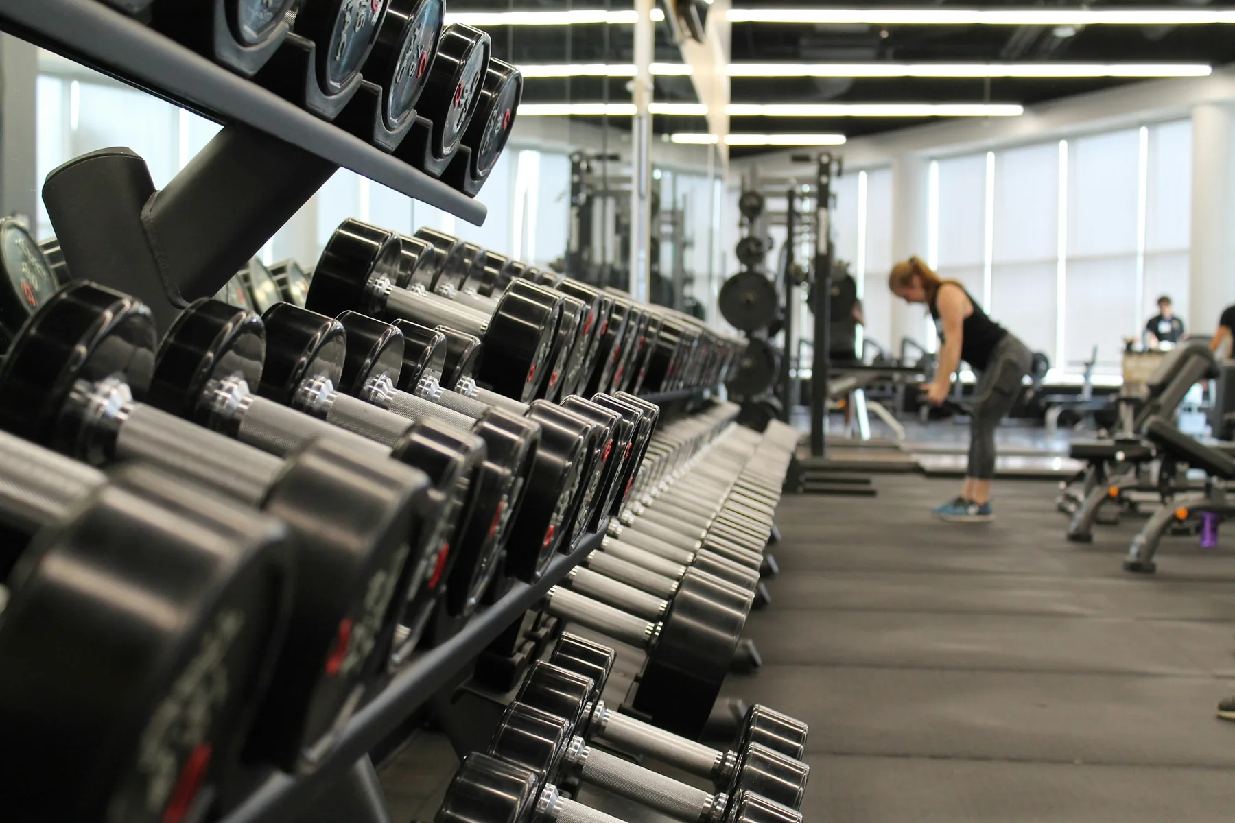 A gym floor with racks and machines in the early morning